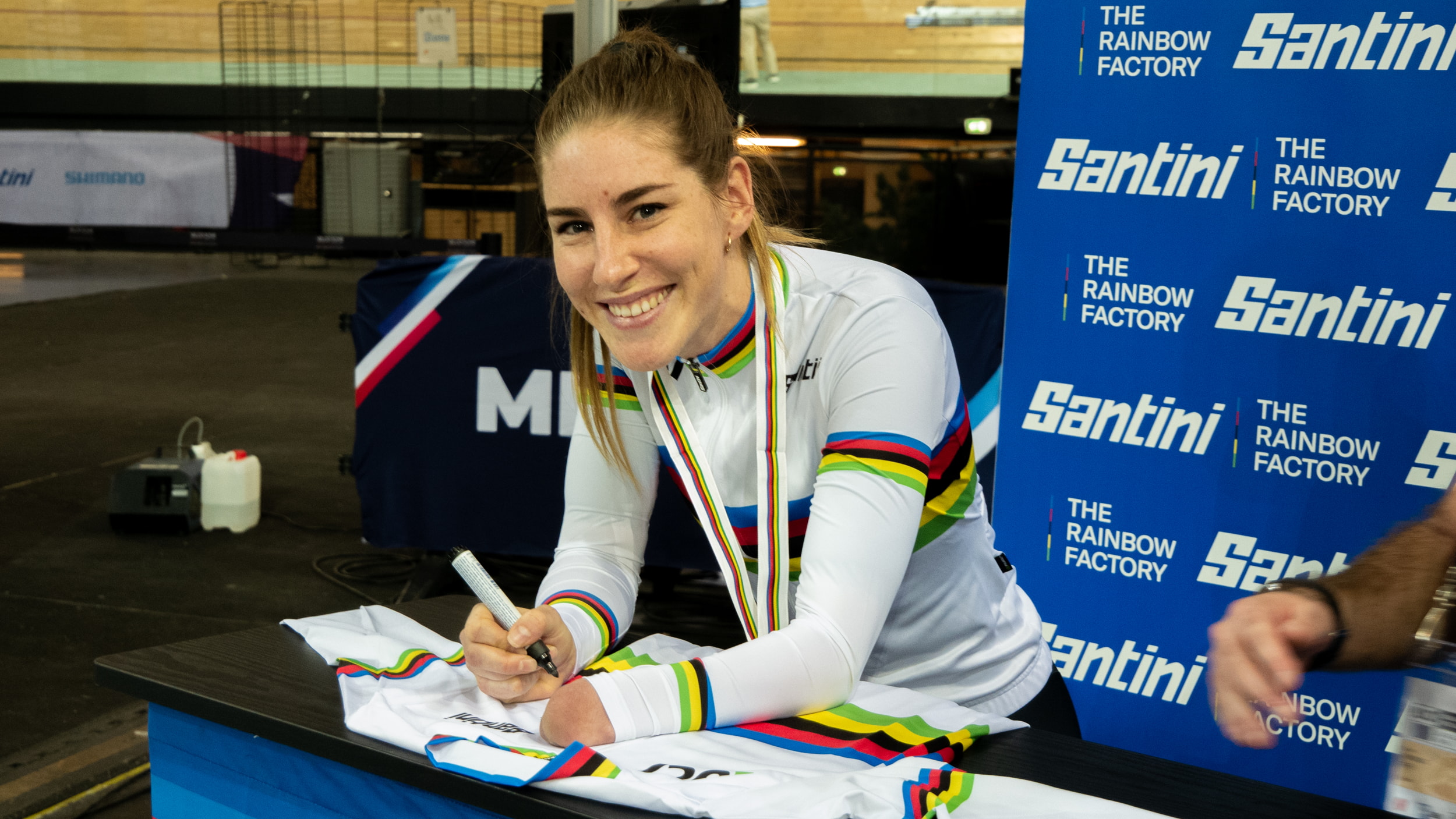 Nicole Murray grins as she signs a rainbow jersey