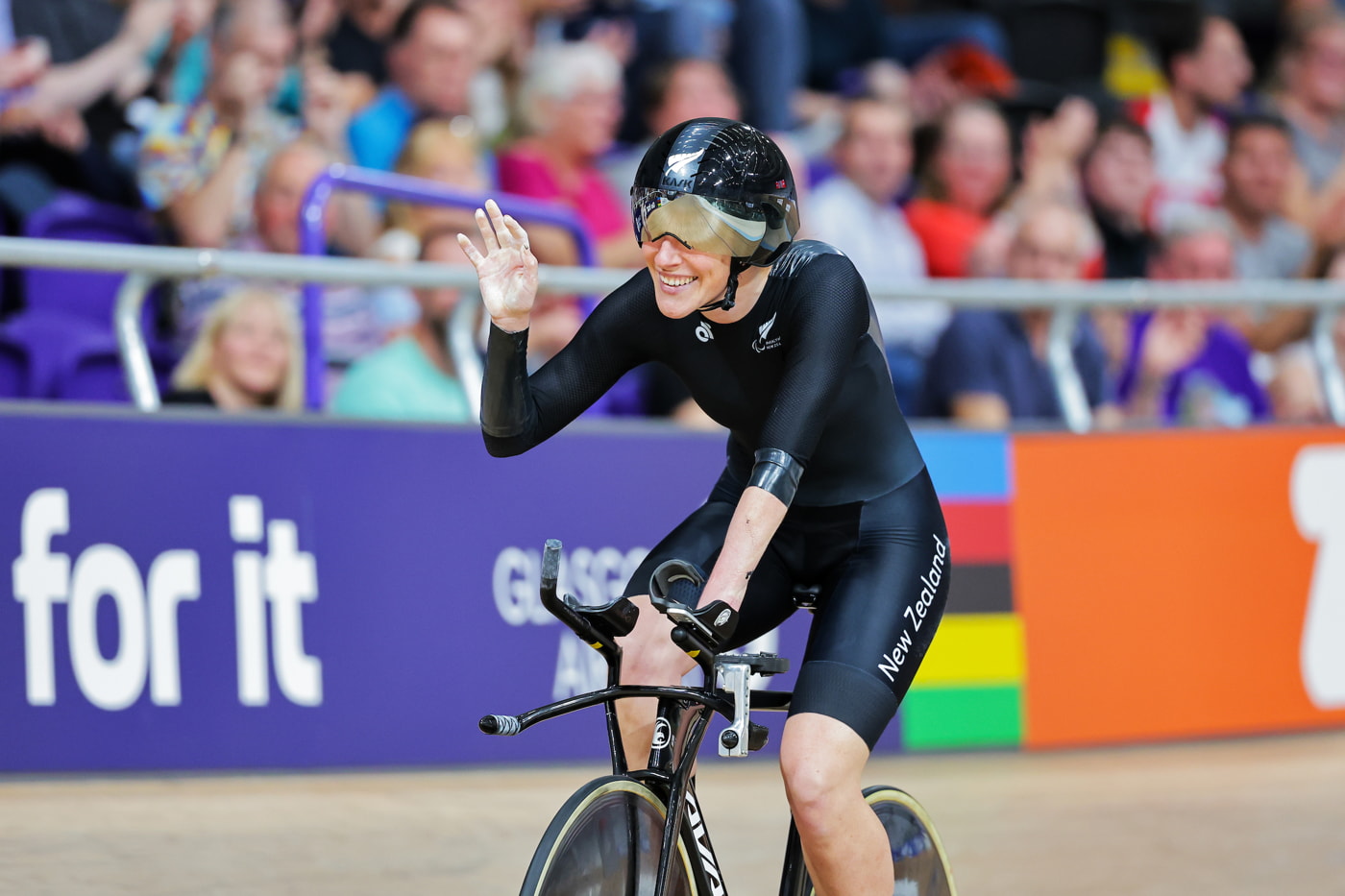 Nicole waves, smiling, as she finishes the race