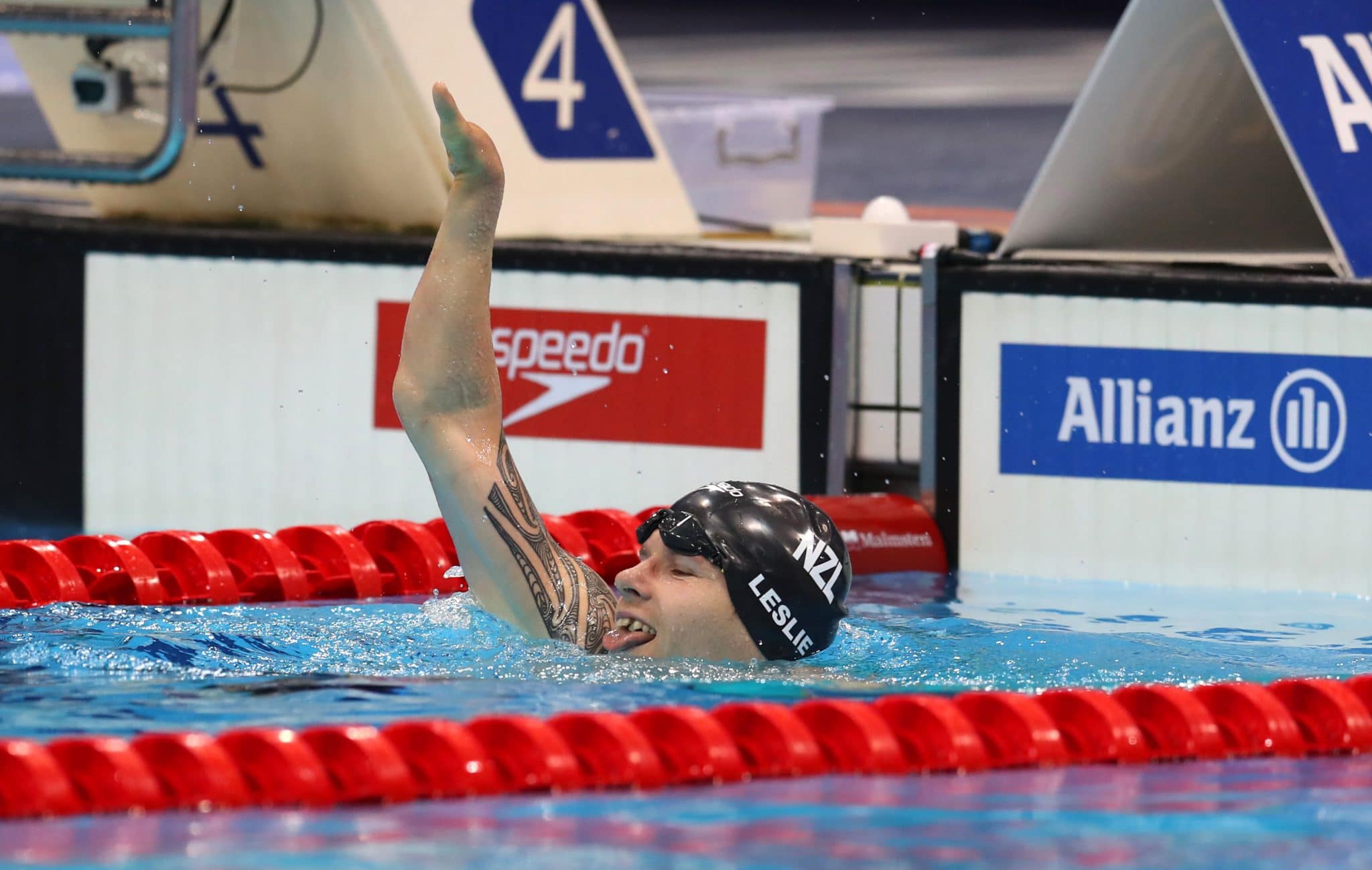 Cameron Leslie raises an arm from the pool, sticking his tongue out cheekily