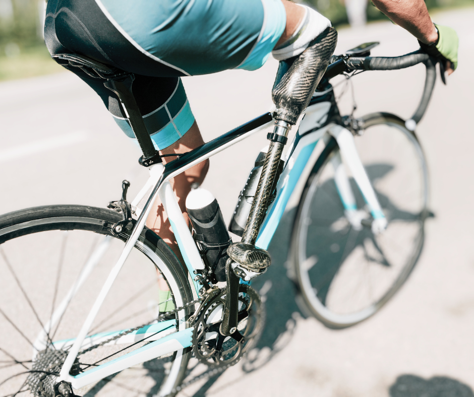 Close up of a male amputee with a specially designed prosthetic on a bike on a road