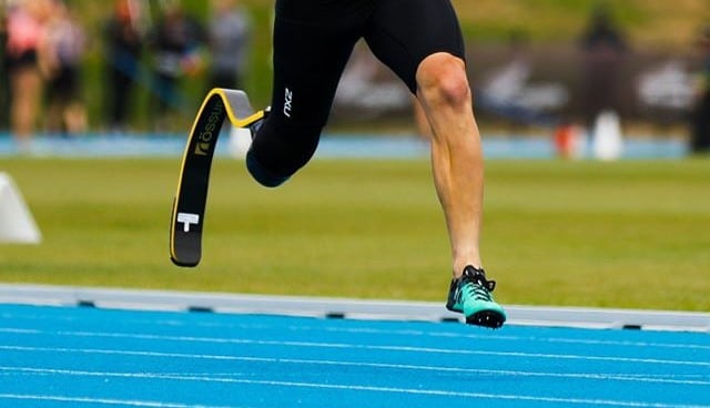 Close up legs of runner on athletics track with a blade