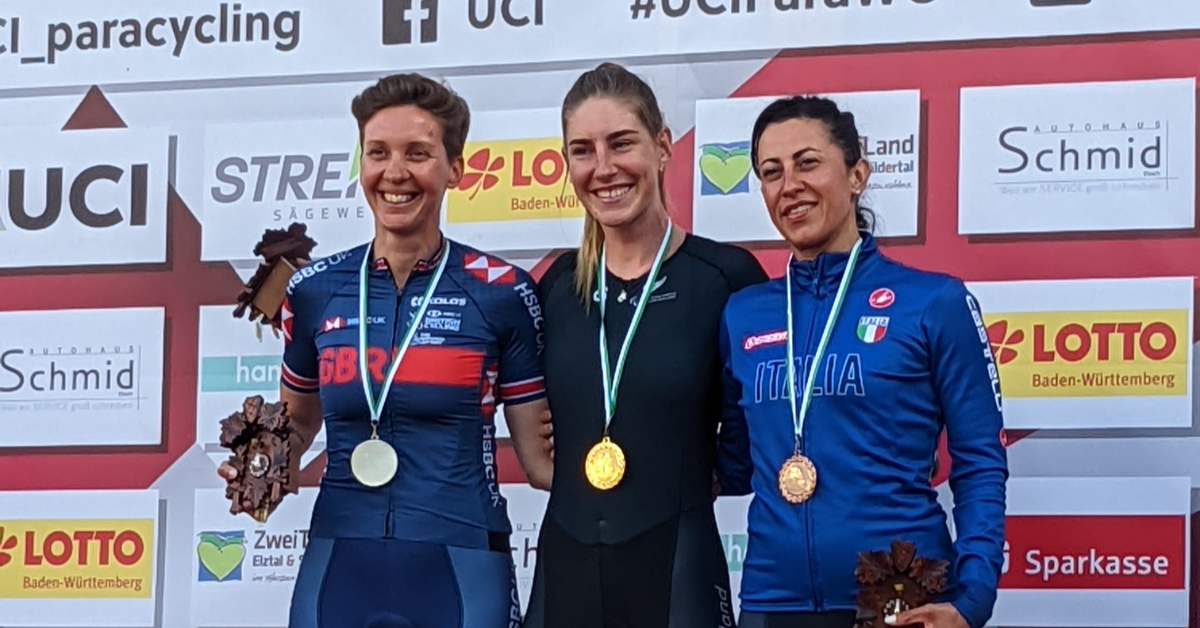 Nicole Murray poses on the podium with two other Para athletes after winning gold